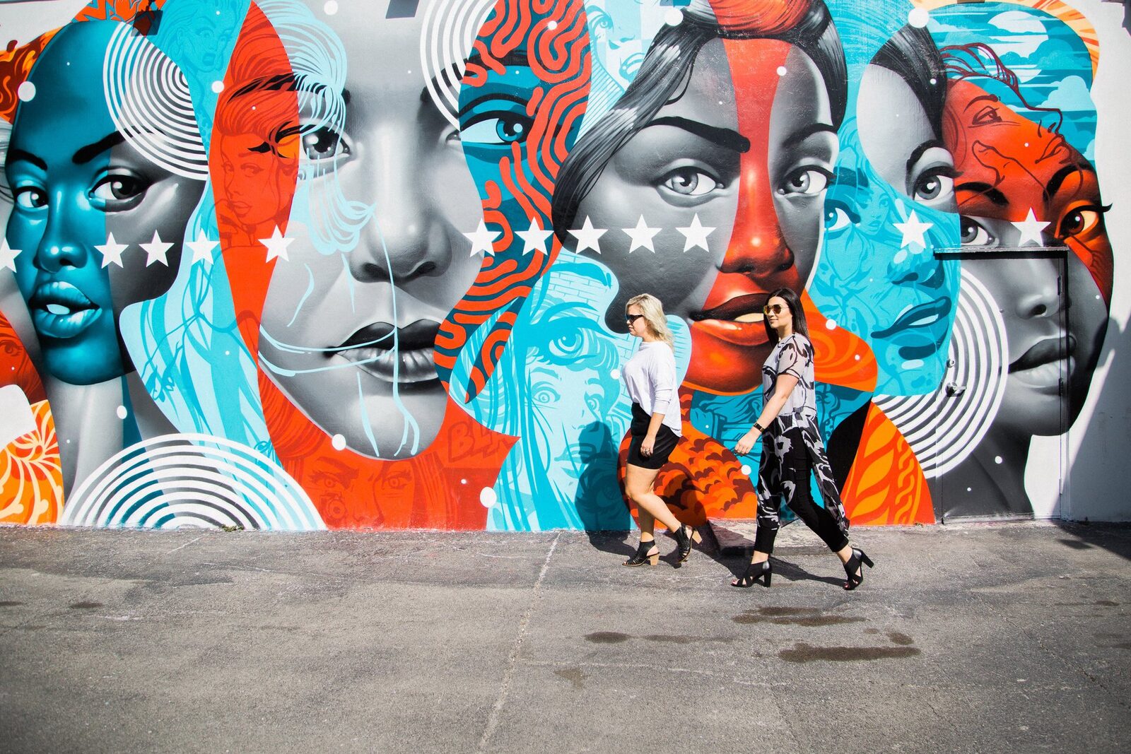 Long vibrant mural with characters and food along an outdoor walkway